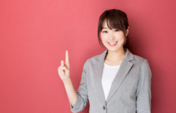 portrait of asian businesswoman pointing on red background