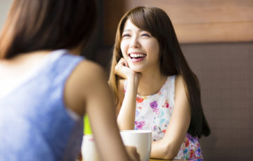 two young woman chatting in a coffee shop